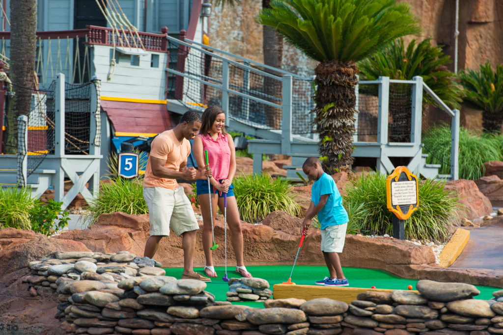 Family playing mini golf